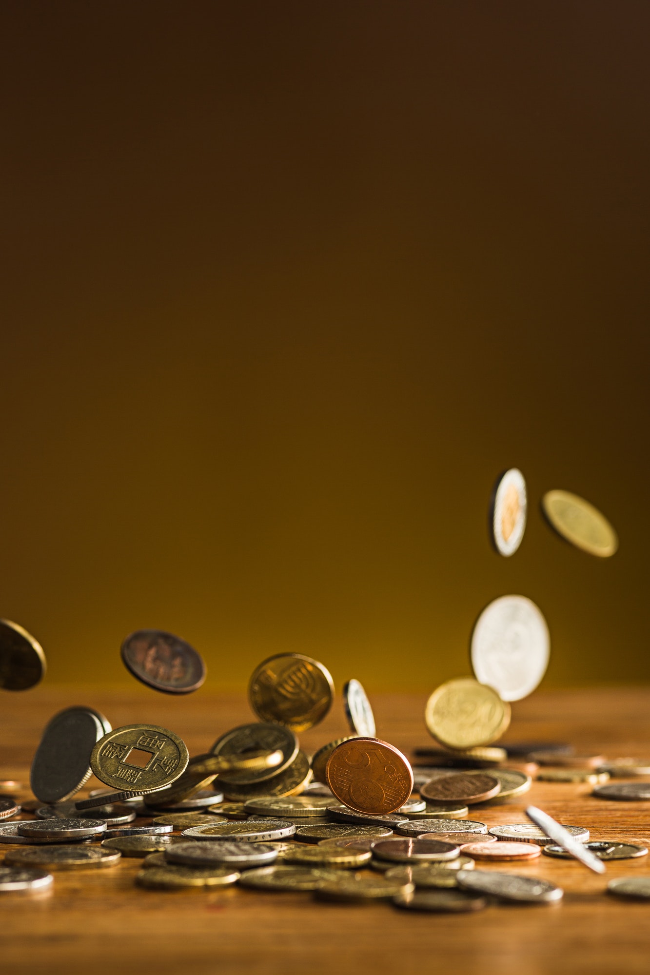 The silver and golden coins and falling coins on wooden background