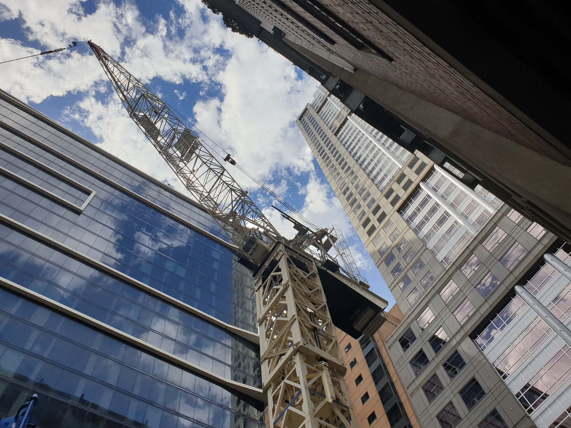 View of Cranes and building construction heavy equipment on site. Construction ongoing